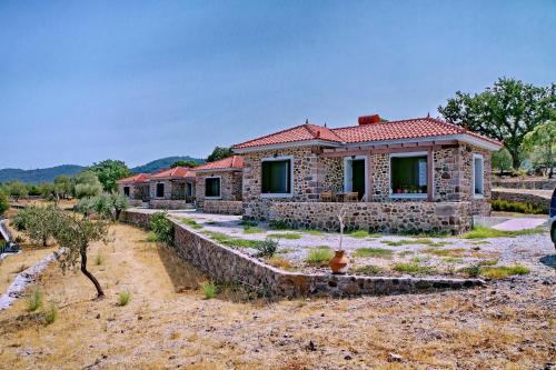 a small stone house in the middle of a field at Ktima Kiourelioti in Skála Sykaminéas