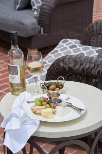 a table with a plate of cheese and a glass of wine at The Groton Inn in Groton