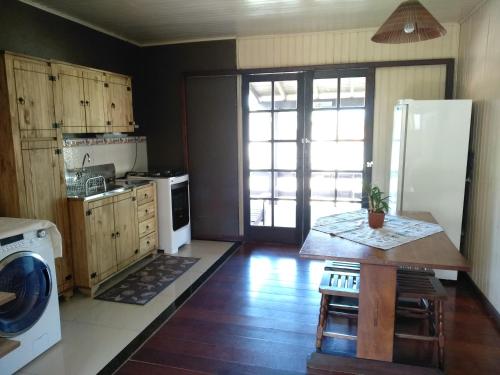a kitchen with a refrigerator and a table in it at Casa a 50 mt da Praia. in Bombinhas