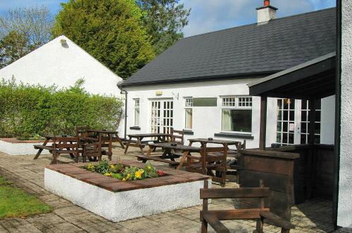 a group of tables and benches in front of a building at Brown Trout Golf & Country Inn in Aghadowey