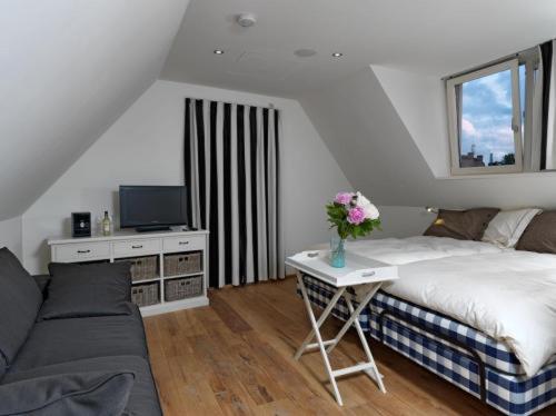 - une chambre avec un lit et une table fleurie dans l'établissement Wellness Caracol, à West-Terschelling