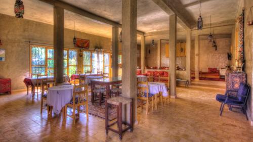 a dining room with tables and chairs in a building at Gite Tamlli in Aoufous