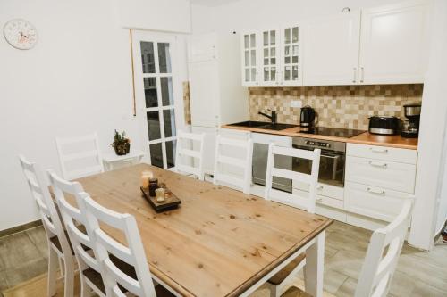 cocina con mesa de madera y armarios blancos en Ferienhaus Schneeweiß, en Winterberg