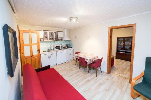 ein Wohnzimmer mit einem roten Sofa und einem Tisch in der Unterkunft Domek na Kaszubach - Cały dla Ciebie! in Lipnica