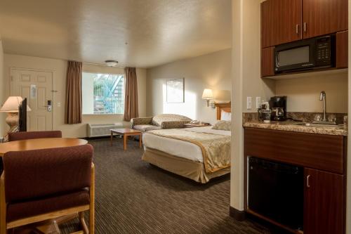 a hotel room with a bed and a kitchen at St. George Inn and Suites in St. George