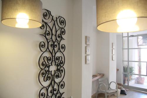 a wall art in a living room with two lights at Las Coles Apartasuites in Xàtiva