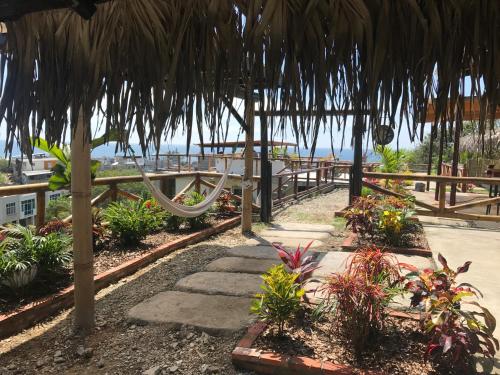 a garden with a hammock and some plants at The Heights in Montañita in Montañita