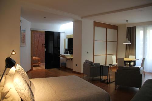 a hotel room with a bed and a living room at Las Coles Apartasuites in Xàtiva