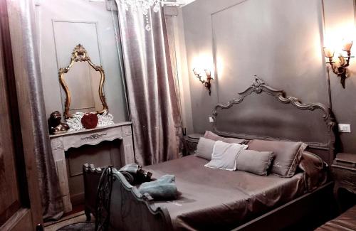 a bedroom with a bed and a fireplace and a mirror at L'Antico Lido Venice in Venice-Lido