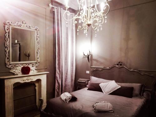 a bedroom with a bed with a mirror and a chandelier at L'Antico Lido Venice in Venice-Lido