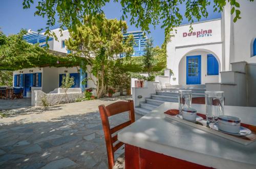 a table with a tray of drinks on it in front of a building at Despina Hotel in Agia Anna Naxos