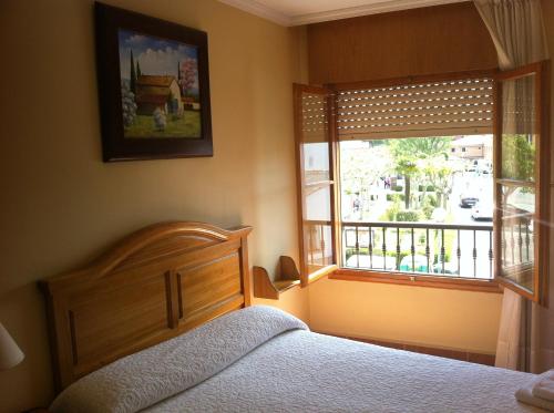 a bedroom with a bed and a window at Hostal Puerta La Villa in Tordesillas