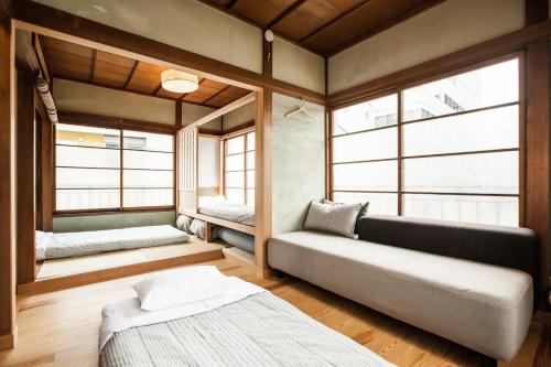 a room with two beds and a couch and windows at Minato-ku - House / Vacation STAY 12127 in Tokyo