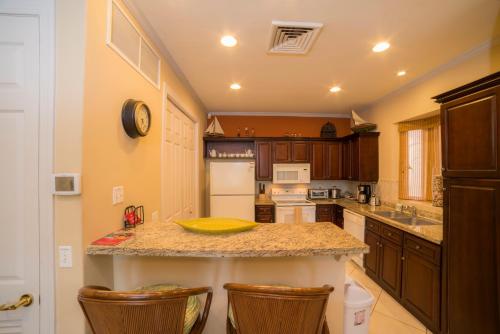 a kitchen with a counter and some chairs in it at Stay In CR Los Sueños Condos in Jacó