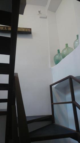 a staircase with a shelf and vases on a wall at Las Coles Apartasuites in Xàtiva