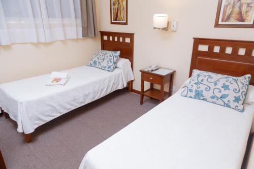 a hotel room with two beds and a table at Hotel Federico I in Concordia