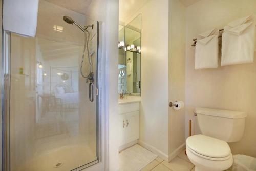 uma casa de banho com um WC e uma cabina de duche em vidro. em Marebello em Fort Bragg