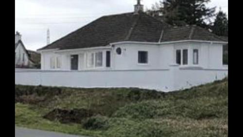 a white house sitting on top of a hill at Skerrols in Broadford