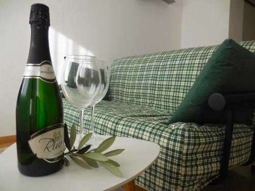 eine Flasche Champagner und ein Glas Wein auf dem Tisch in der Unterkunft Olive Tree House in Riva del Garda