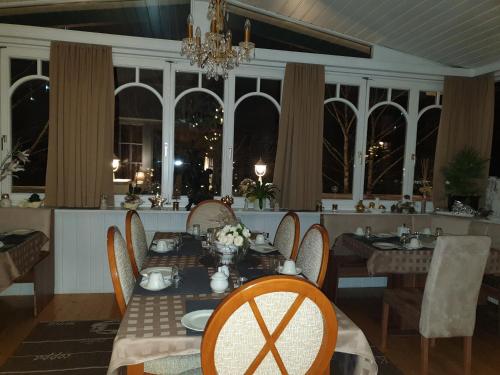 een eetkamer met een tafel, stoelen en ramen bij Villa Elisabeth in Admont