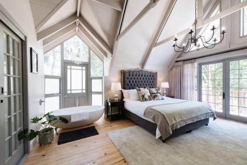 a bedroom with a large bed and a chandelier at Simonzicht Guest House in Stellenbosch