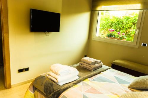 a room with a bed and a window and a television at B&B Tina de Pacs, close to local wineries in Pacs del Penedes