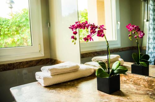 a bathroom with towels and flowers on a counter at B&B Tina de Pacs, close to local wineries in Pacs del Penedes