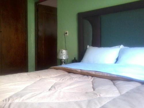 a bedroom with a large bed with white sheets at Gîte Atlas Mazik in Imlil