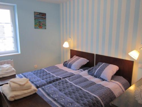 a bedroom with a bed with a blue comforter and pillows at Gîte Faubourg des Pierres in Sigolsheim