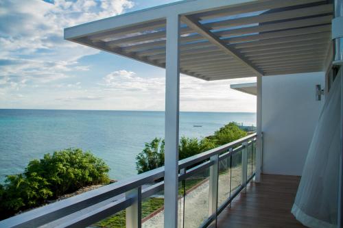 a balcony with a view of the ocean at Pearl of Santa Fe - Sabal's Lodge in Bantayan Island