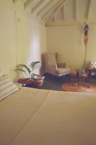 a living room with a bed and a couch and chairs at The Village Anjuna in Anjuna