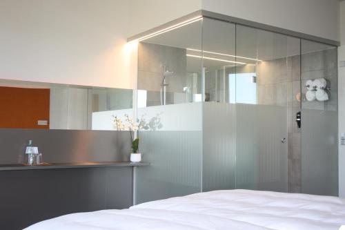 a bedroom with a glass shower and a bed at Scala Turm Hotel Restaurant in Jena