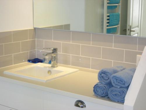 une salle de bain avec un lavabo, un miroir et des serviettes dans l'établissement VILLA DU GOLFE T3 Beaurivage, à La Ciotat