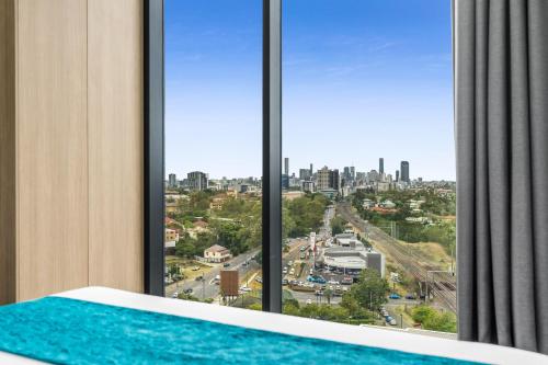a room with a large window with a view of a city at Essence Suites Taringa in Brisbane