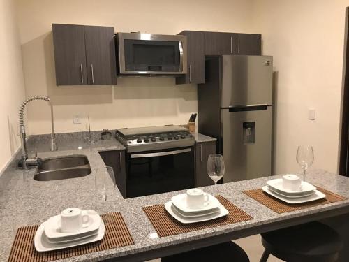 a kitchen with a counter with a sink and a refrigerator at Beautiful 3 BR/3.5 bath Home@Selvanova in Playa del Carmen