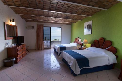 een hotelkamer met 2 bedden en een balkon bij Decameron Los Cocos - All Inclusive in Rincon de Guayabitos