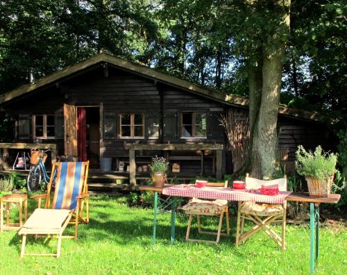 stół piknikowy i krzesła przed kabiną w obiekcie Blockhütte 35 km nördlich von Hamburg w mieście Langeln