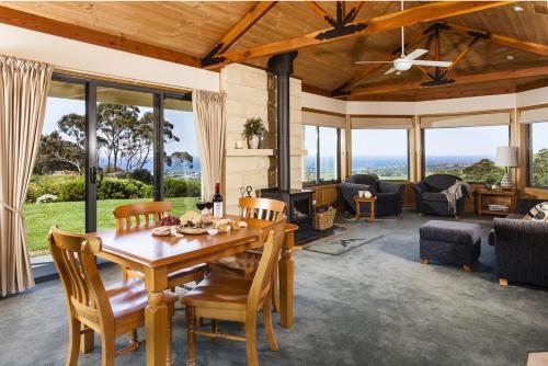 a living room with a wooden table and chairs at Glenoe Cottages in Apollo Bay