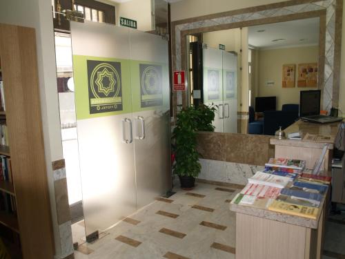 an office lobby with a reception desk and a door at Hotel Al-Yussana in Lucena