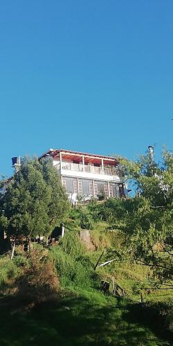 a large white building on top of a hill at Hotel El Cangrejo in Paipa