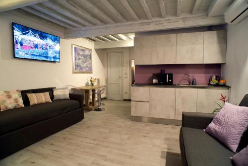 a living room with a couch and a kitchen at Giulietta Suite - Brand New flat in Santa Maria Novella in Florence