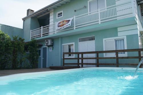 a large swimming pool in front of a building at Pousada Cravo e Canela in Palhoça