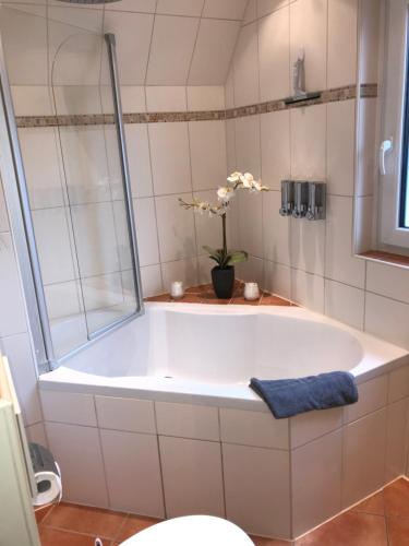 un bagno con vasca e vaso di fiori di Ferienwohnung Stargardt Eimbeckhausen a Bad Münder am Deister