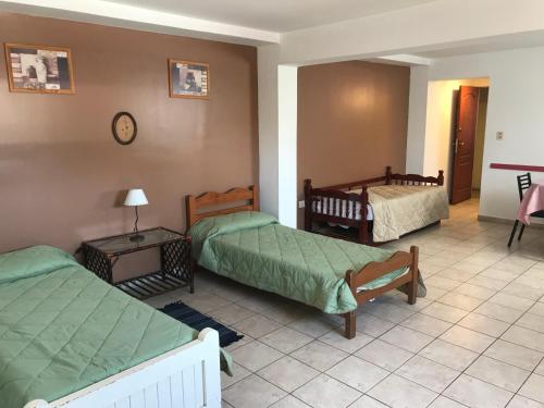 a room with three beds and a clock on the wall at Departamento Belgrano III in Salta