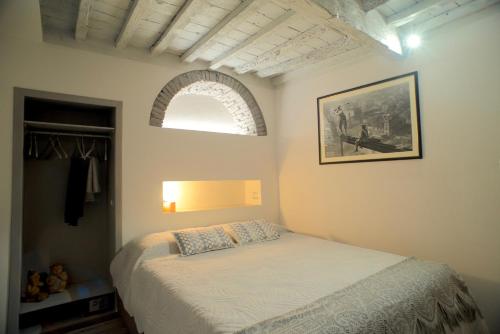Schlafzimmer mit einem Bett und einem Bogenfenster in der Unterkunft Giselle Suite - Brand new flat in Santa Maria Novella in Florenz