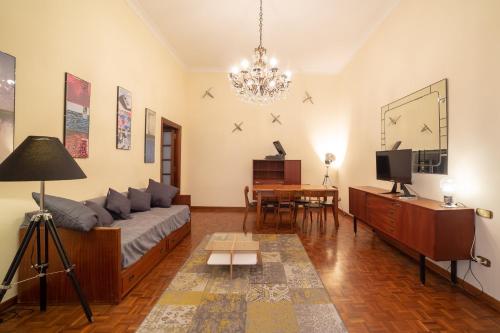 salon z kanapą i telewizorem w obiekcie The Dante Apartment By HouseinNaples w mieście Neapol