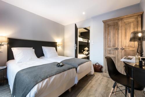 a bedroom with a large bed and a desk and a chair at Résidences Alticimes in Brides-les-Bains