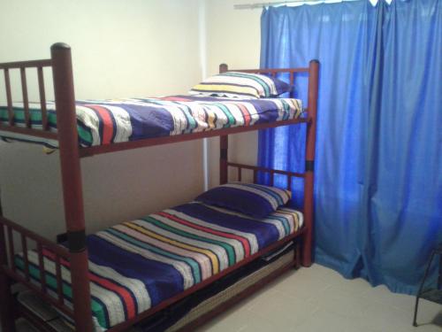 2 literas en una habitación con cortinas azules en Casa Bahia Inglesa, en Bahía Inglesa