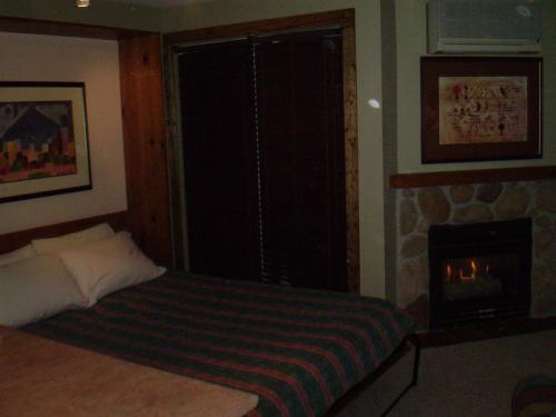 - une chambre avec un lit et une cheminée dans l'établissement Studio suite located in the heart of Whistler village, à Whistler