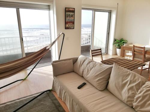a living room with a couch and a hammock at Mar Beach Apartment in Póvoa de Varzim